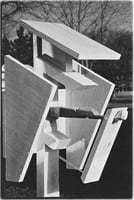 Geometric wooden shapes poised to come together to form a nest box.